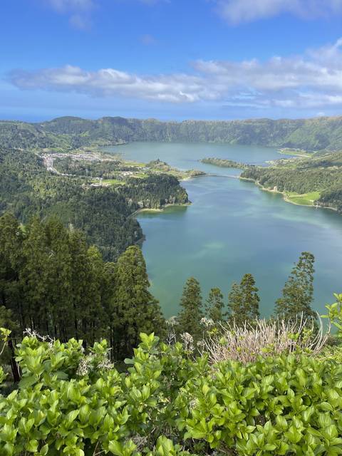 Overhead view of blue and green lakes surrounded by greenery.