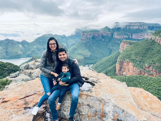       Family posing on a mountain overlook with scenic landscape views.
  