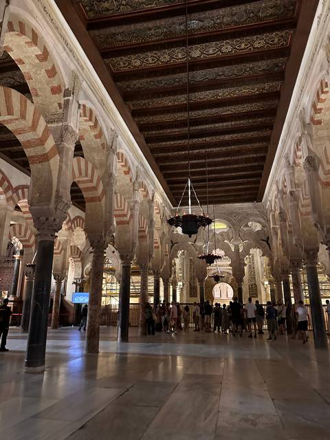       Interior of a historic building with arches and intricate design.
  