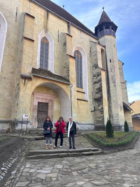       Group of people in front of a historical church facade.
  