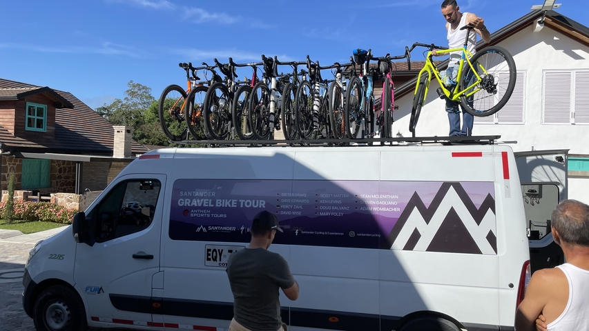 Group managing bicycles on top of a van.