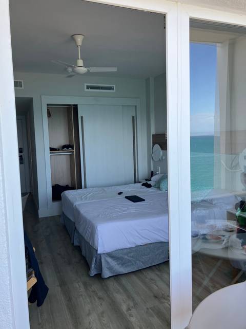      Interior of a hotel room with bed and a view through a glass window.
  