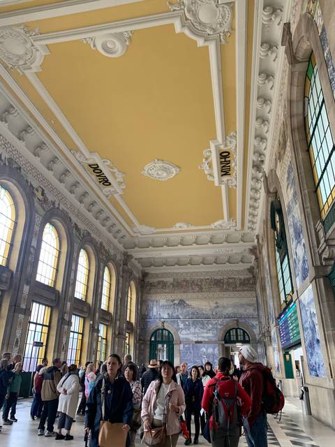      A decorated interior with a crowd of people inside a station.
  