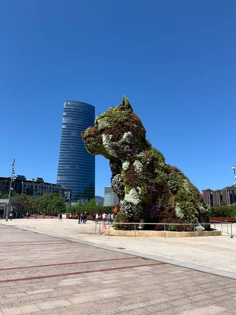       A large floral sculpture in front of a modern building.
  