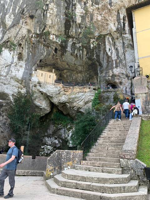       A rocky area with carved steps leading to a small building.
  