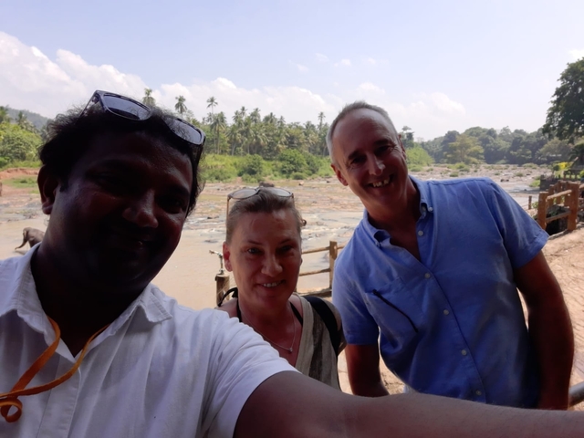       Three people taking a selfie near a river with trees in the background.
  