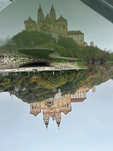       Large yellow building with a reflection in the water.
  