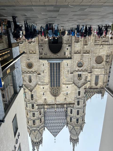       Crowd gathered in front of a large ornate building with a tiled roof.
  