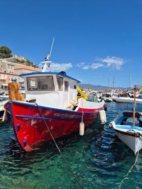 Colorful small boat docked at a marina.