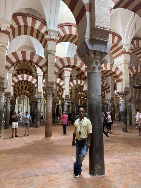 Person inside a historic building with arches.