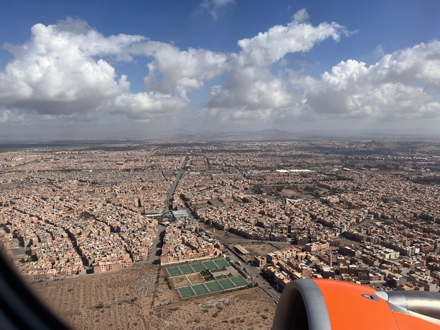       Aerial view of sprawling cityscape with roads and buildings.
  