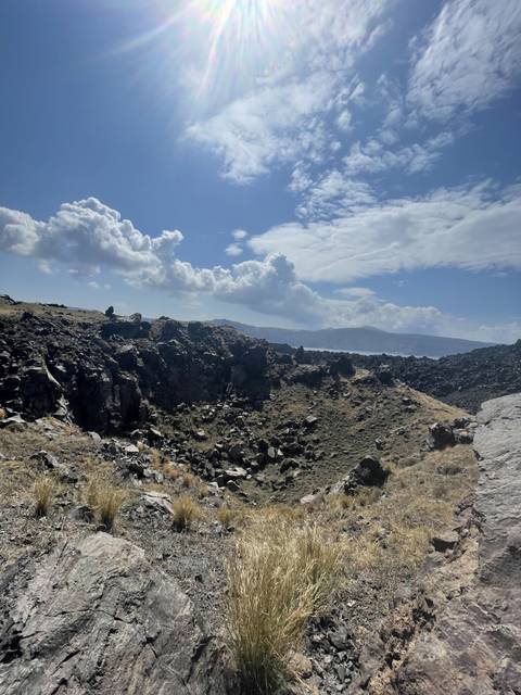       Rugged landscape with rocky terrain under a blue sky.
  