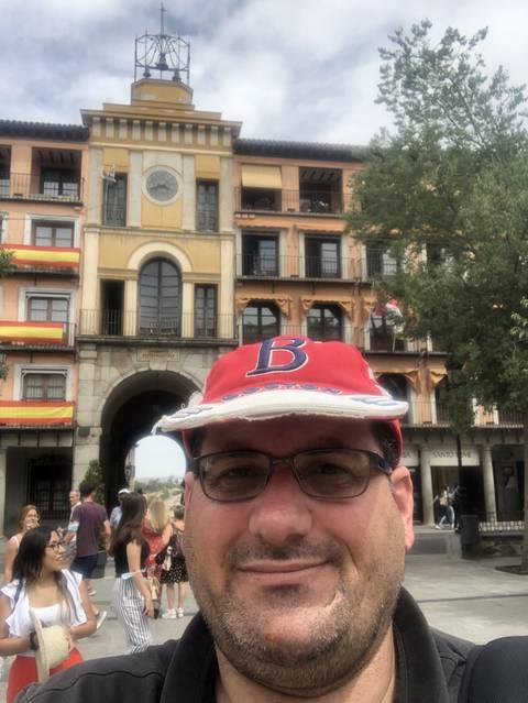 Selfie of a man in front of a colorful historic building.