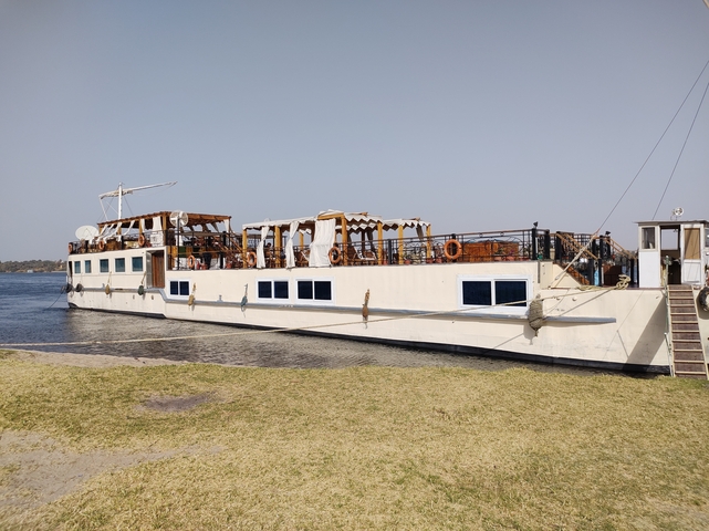       Close-up view of a moored tourist boat by the shore.
  