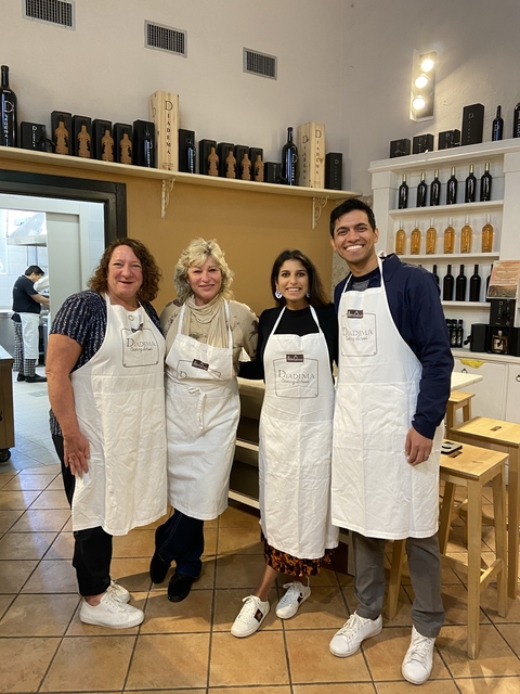 Group of people in a cooking class wearing aprons.