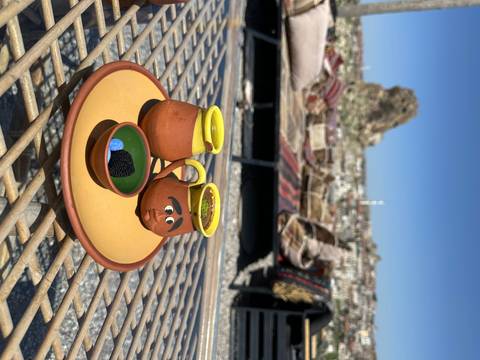       Colorful pottery set on a table overlooking a scenic view.
  