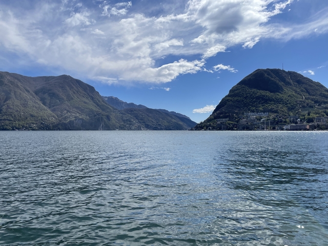 A serene lake bordered by lush green mountains.