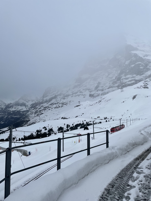 Snow-covered mountain landscape with a red train.