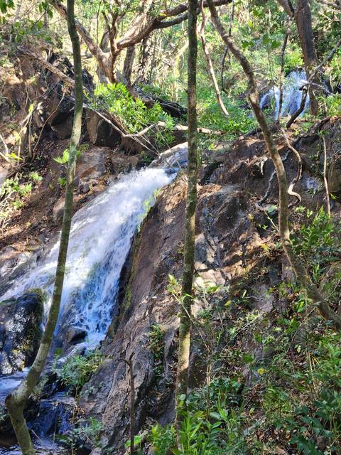       Small waterfall coursing through a rocky terrain.
  
