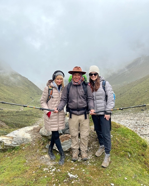       Hiking group posing at a mountain pass under cloudy skies.
  