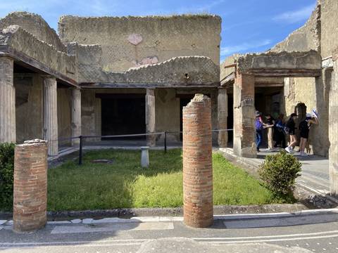       People exploring ruins with columns and ancient architecture.
  