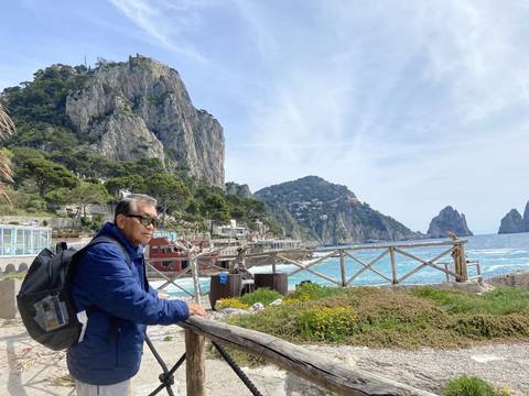       Man observing the coastline with the sea and cliffs.
  