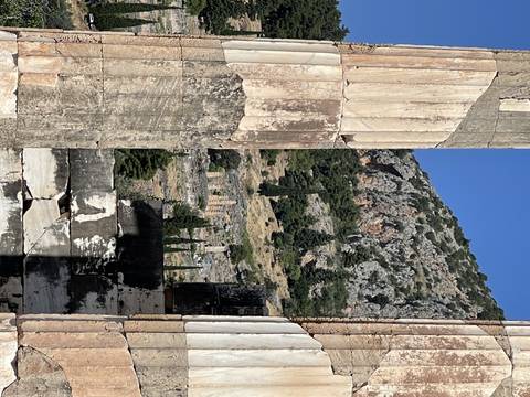 Upside-down view of ancient ruins on a hill.