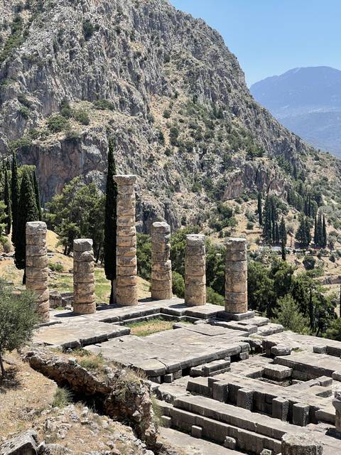       Sideways view of ancient columns in a mountainous landscape.
  