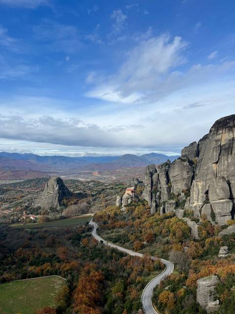       Scenic view with towering rock formations and a winding road.
  