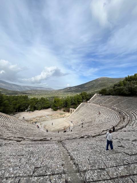       Large outdoor ancient amphitheater with a mountainous backdrop.
  