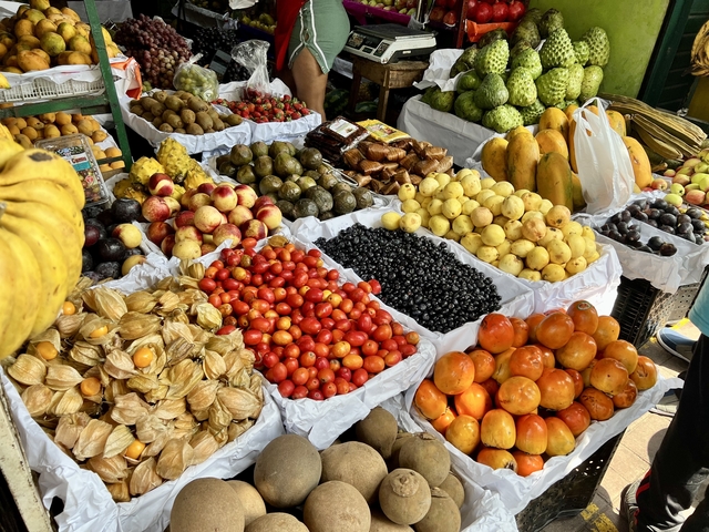 A market stall with a variety of fresh fruits and produce.