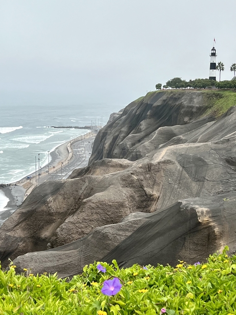       A coastal road and rugged cliffside with the ocean below.
  
