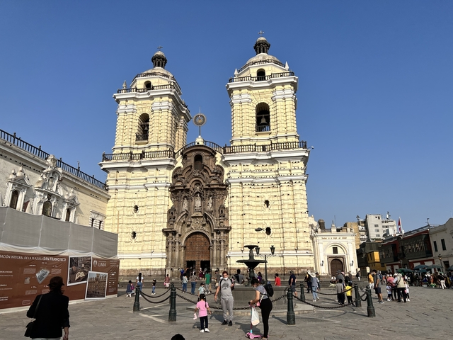 A large historical cathedral with people gathered outside.
