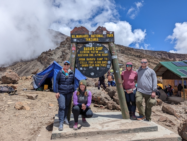       Group posing at a sign for Barafu Camp in Kilimanjaro National Park.
  