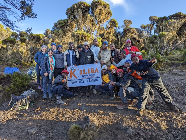       Large group with a tour banner in the wilderness.
  
