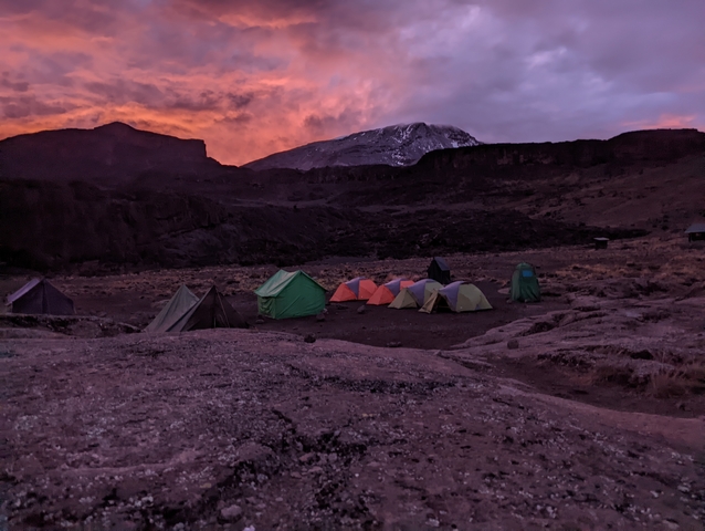       Tents set up in a mountain campsite at sunset.
  