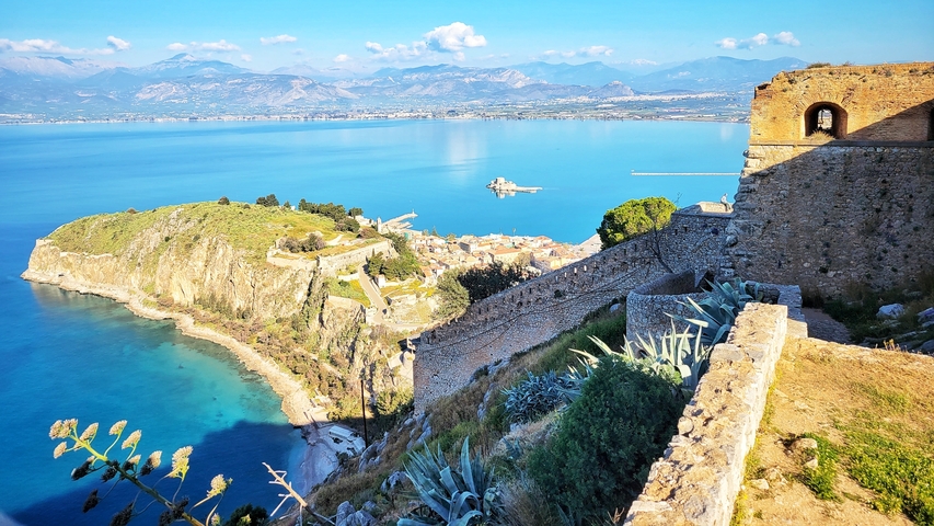 Coastal view with a fortress overlooking a bay.
