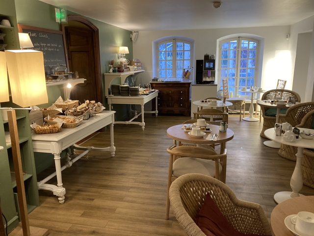       Cozy dining area with tables and chairs set up for breakfast.
  