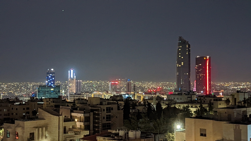 Modern skyscrapers illuminated at night in a cityscape.