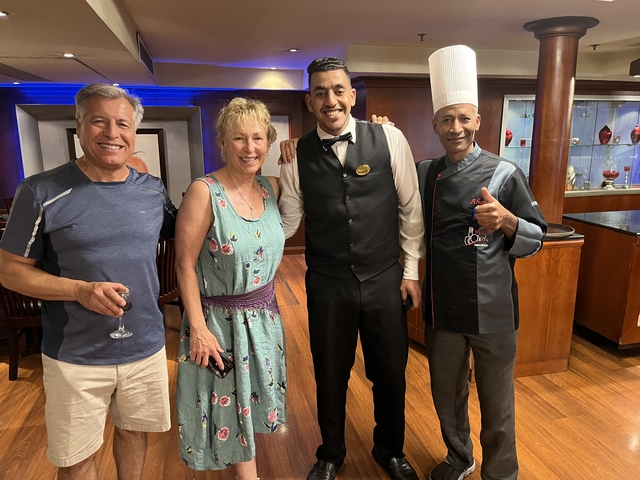       Couple posing with staff in a restaurant setting
  