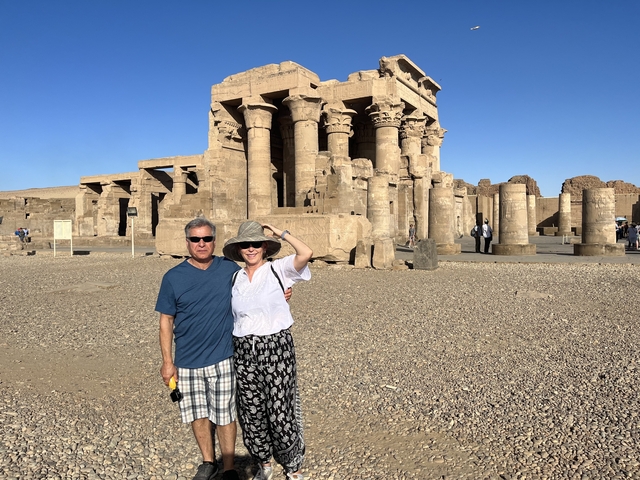 Two tourists posing in front of Kom Ombo Temple.