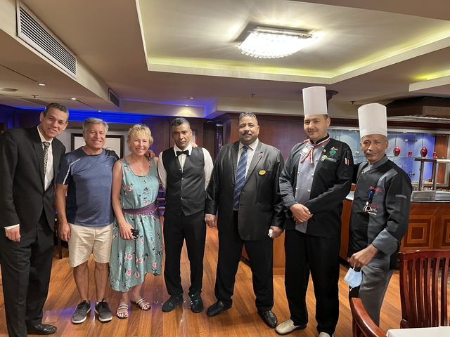 Group posing with waitstaff on a ship