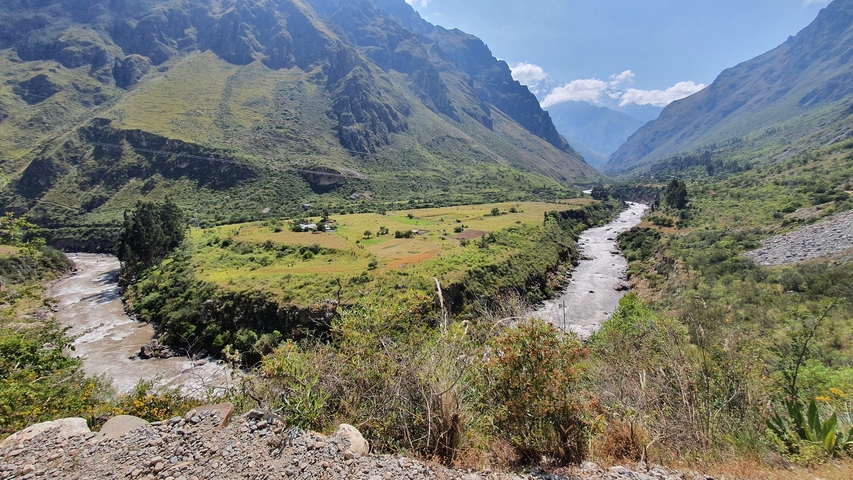 Aerial view of a river cutting through a valley with mountains.