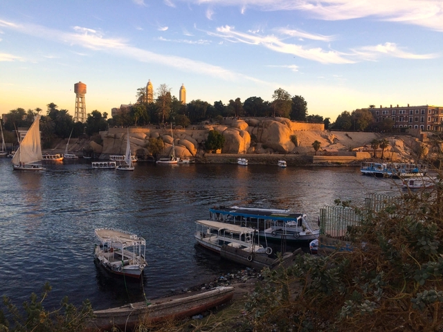 Scenic view of the river with boats docked along the shore during sunset.