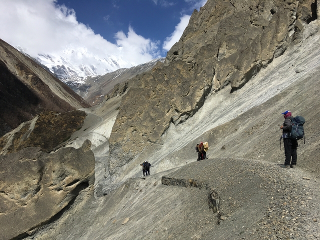       People trekking through a rocky mountain path.
  