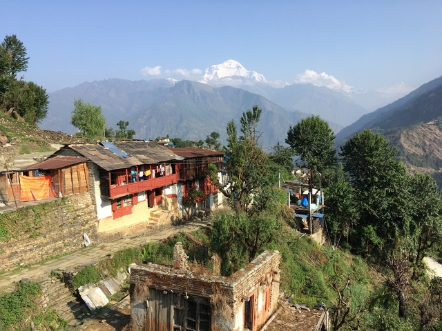 Traditional village with mountains in the background.