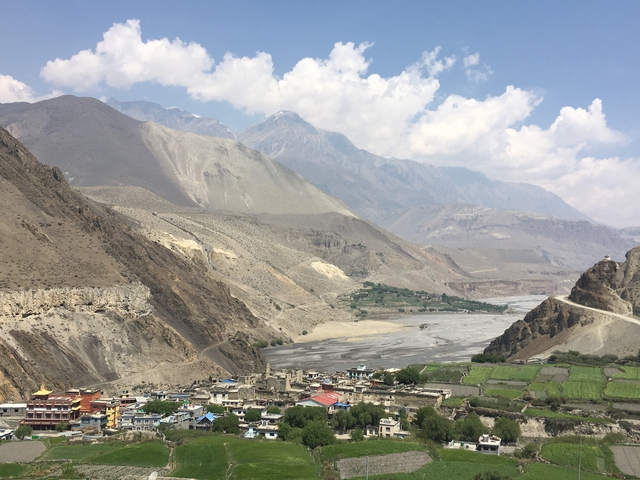       Arid landscape with riverbed and distant mountains.
  