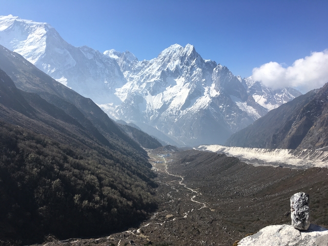 Dramatic mountain valley with snow and a winding path.