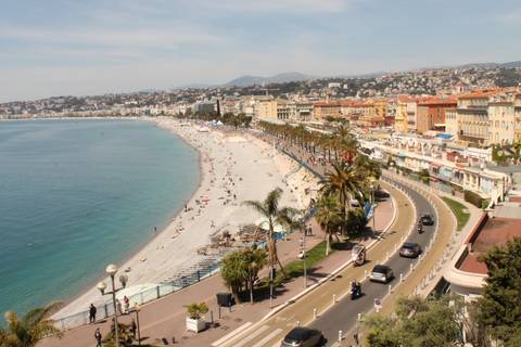      Coastal view of Nice with a beach and promenade.
  