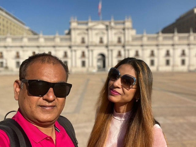 A couple taking a selfie with a historic building in the background.